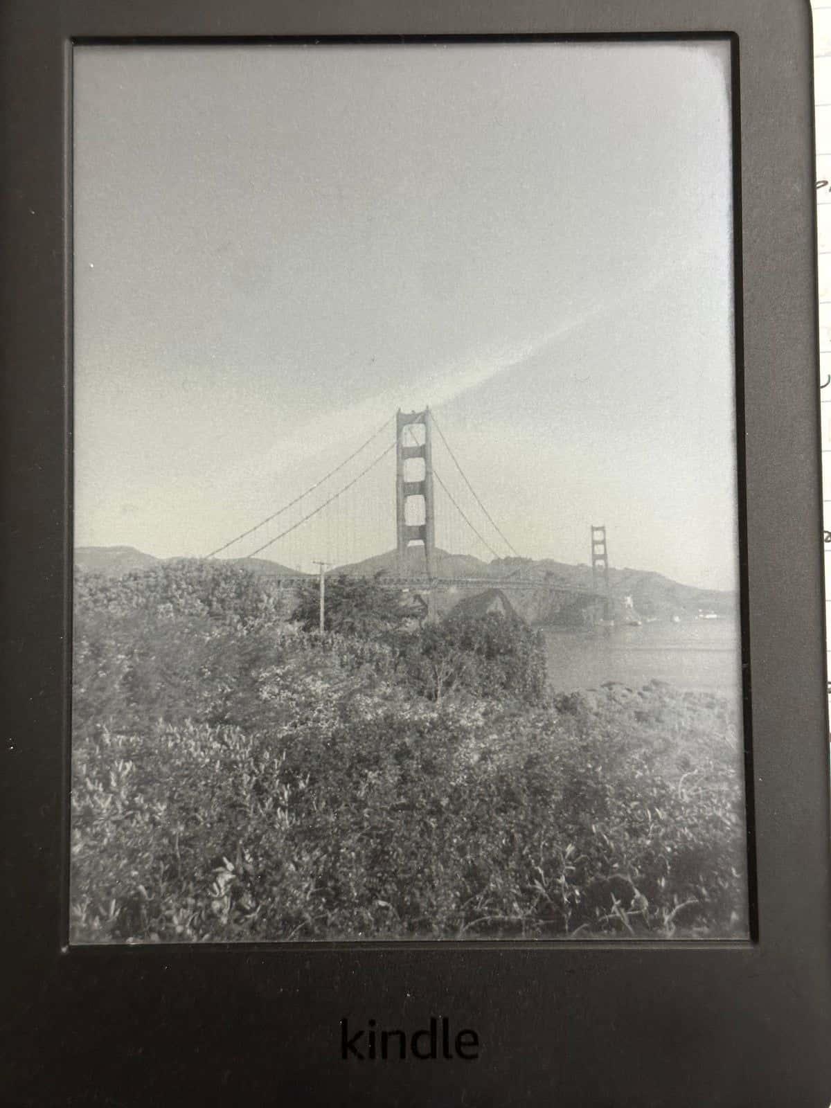 A Kindle displaying a Golden Gate Bridge photo as its custom screensaver