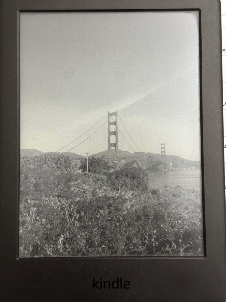A Kindle displaying a Golden Gate Bridge photo as its custom screensaver